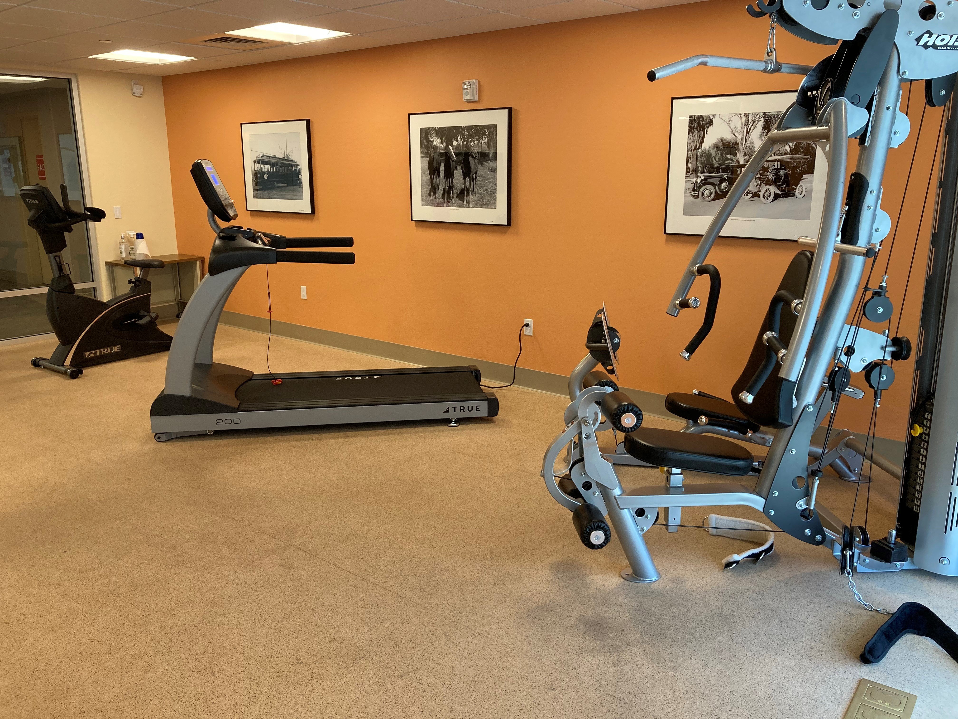 a home gym with exercise equipment and a treadmill